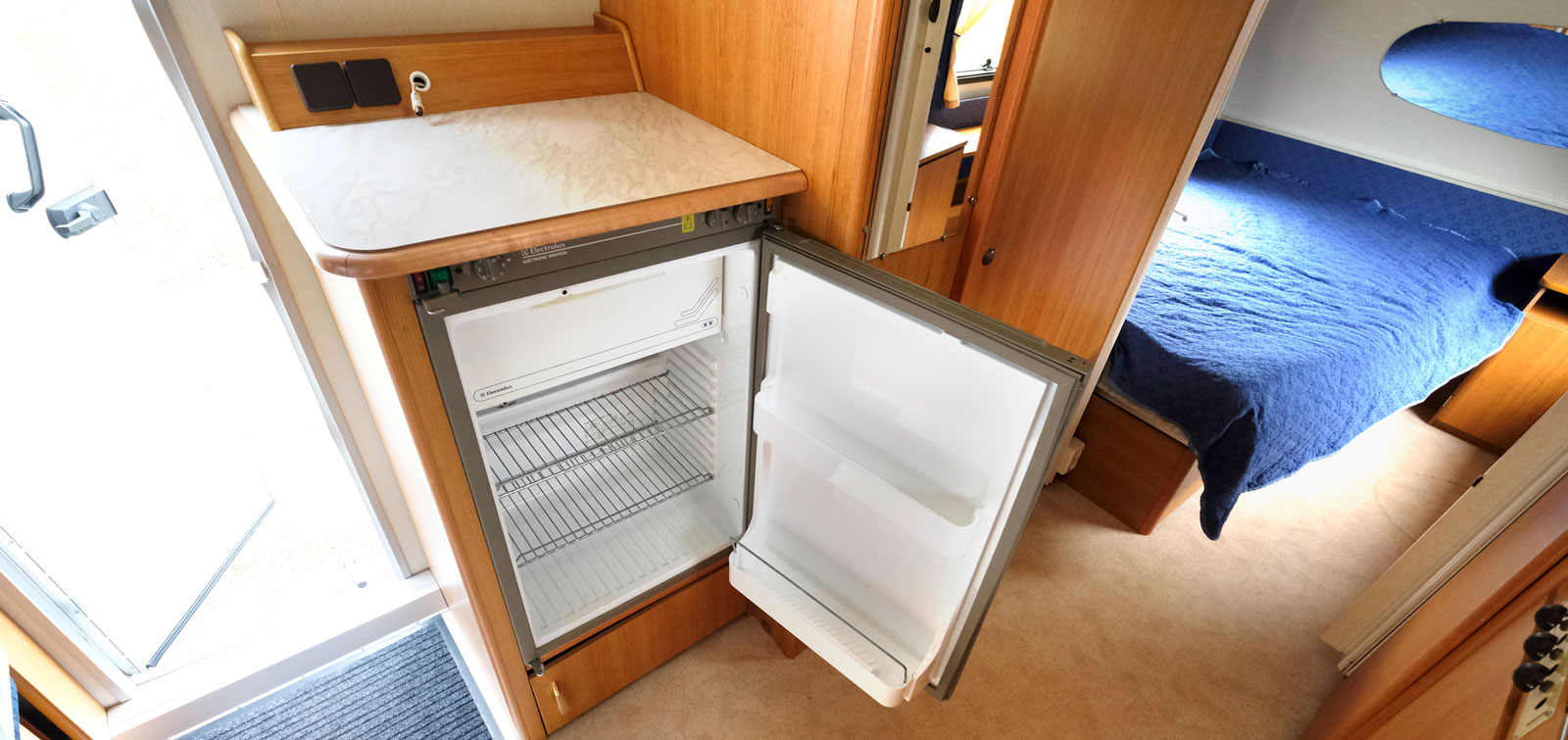 Kylskåpet är placerat mittemot köket bredvid hygienutrymmet.