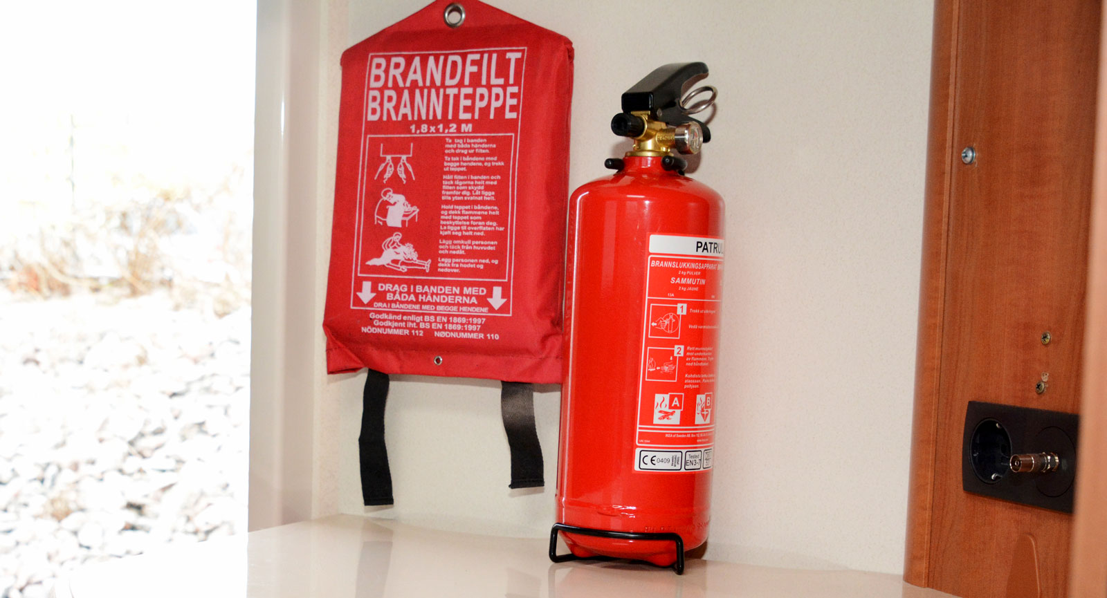 Brandfilt och brandsläckare ska förvaras lättåtkomligt, gärna nära dörren. På vårt testexemplar är inte brandsläckaren monterad i väggen. Det är rekommenderat att den sitter fast eftersom man annars måste packa upp och ned brandsläckaren när fritidsfordonet flyttas. Lämplig brandsläckare är en pulversläckare på sex kilo.