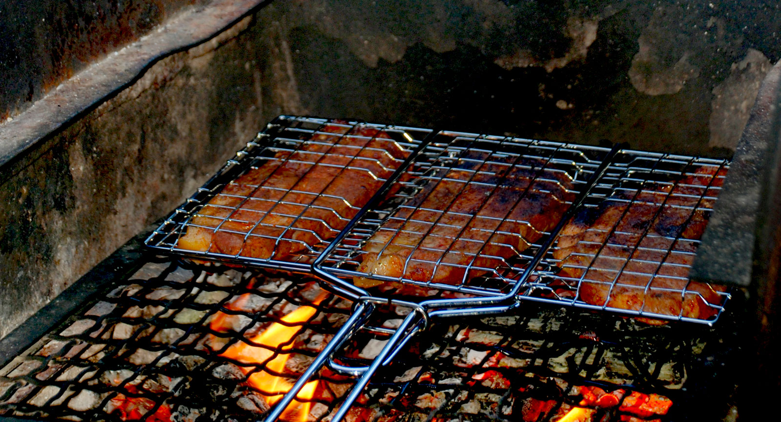 Eldstäderna utmed Sörmlandsleden är ofta murade och försedda med grillgaller. Här grillas fläskkarré till middagen.
