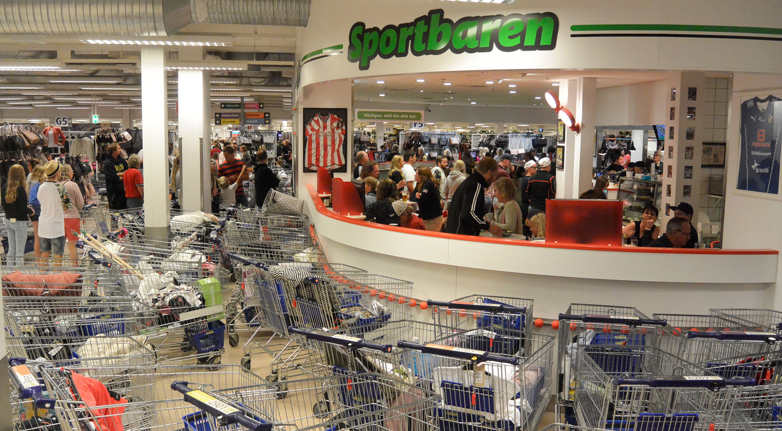 Kundvagnsparkeringen utanför den shoppingfredade zonen, Sportbaren.