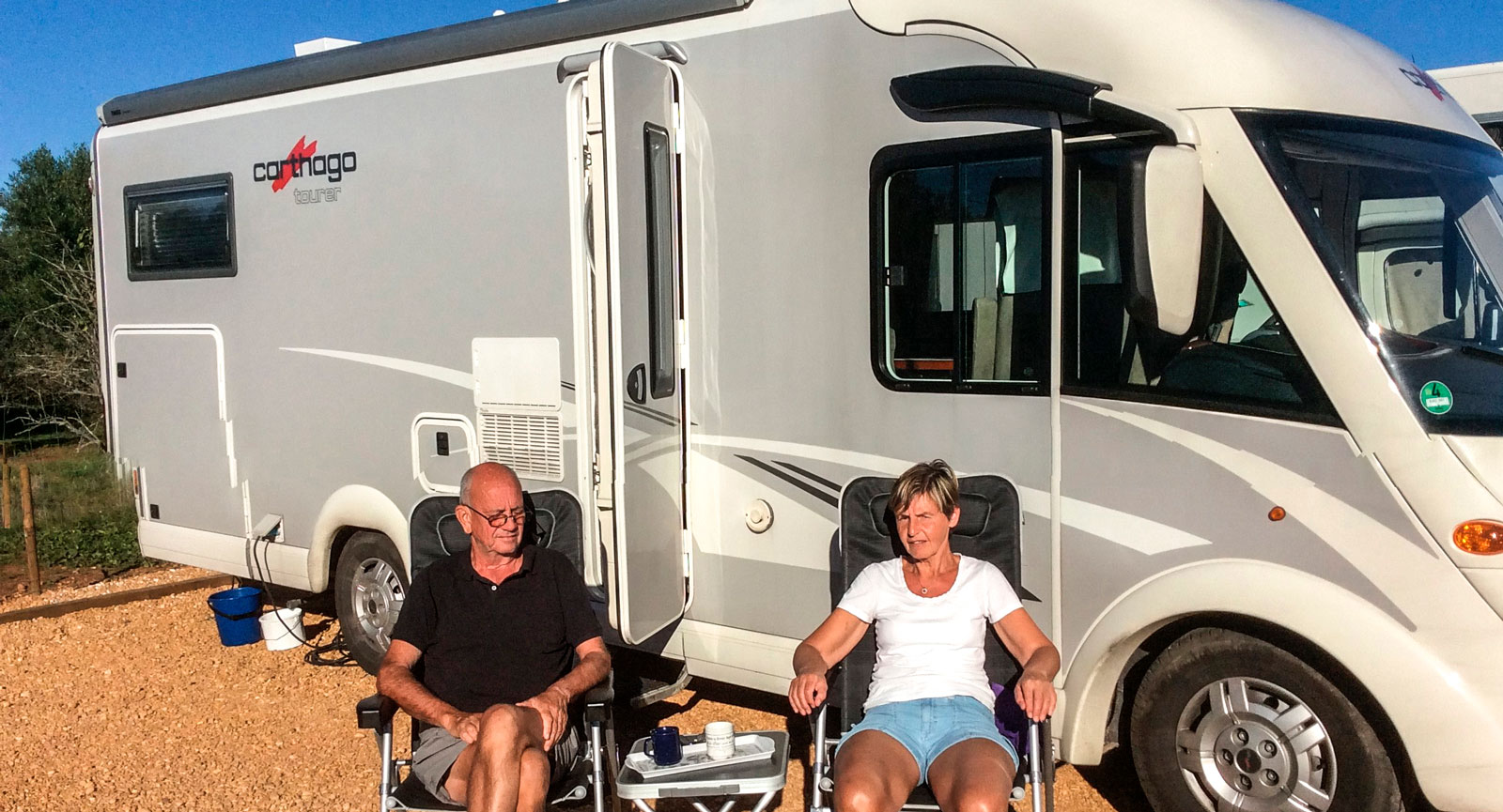 Lennart Nilsson och Britt-Inger njuter av eftermiddagssolen vid husbilen på Motorhome Park Silves längs Algarvekusten.
