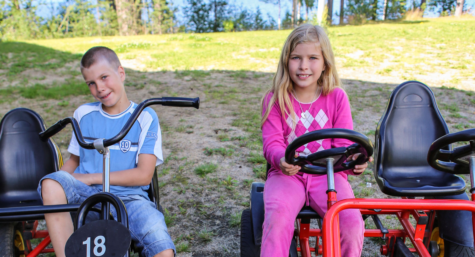 Syskonen Jesper och Jessie gillar trampbilarna som finns på området.