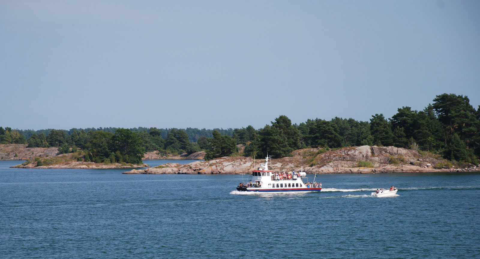 En av Skärgårdslinjens turbåtar passerar utanför campingen.