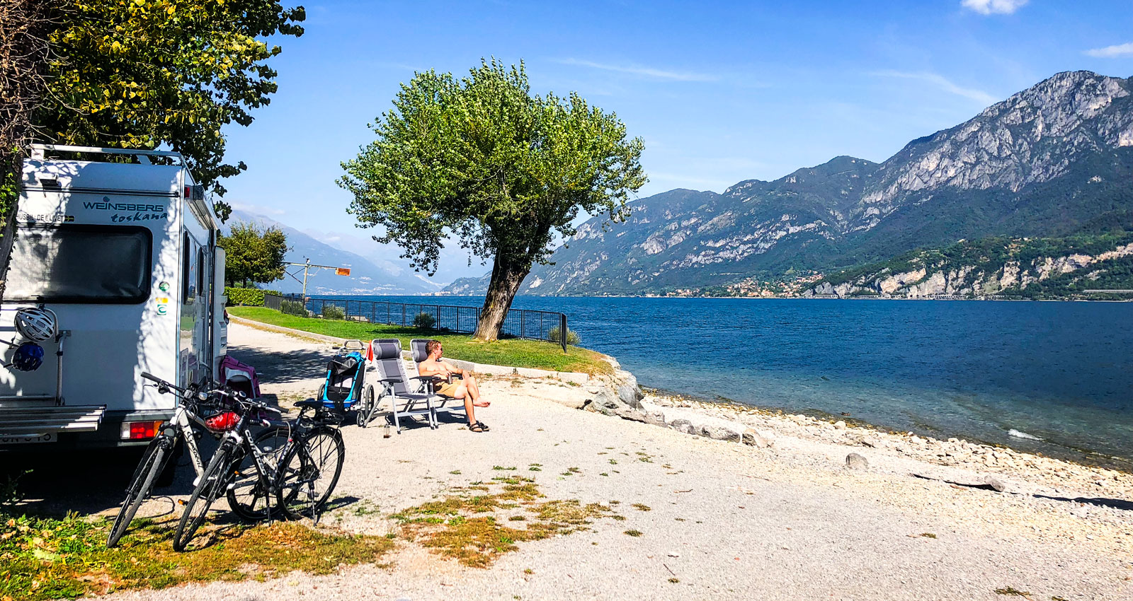 Barnet sover och föräldrarna njuter av utsikten vid Comosjön, Italien.