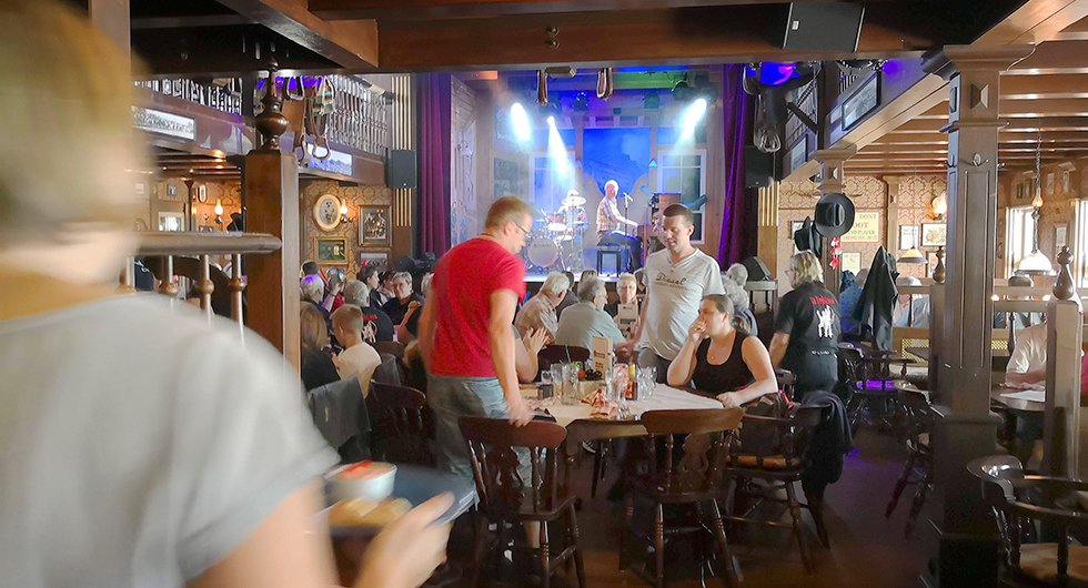 Campingens stora restaurang med livemusik och glada gäster. Strax intill finns en mindre taverna där frukost serveras.