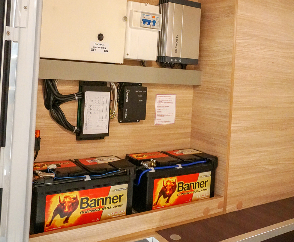 Elcentral i garaget med säkringar och dubbla bodelsbatterier.