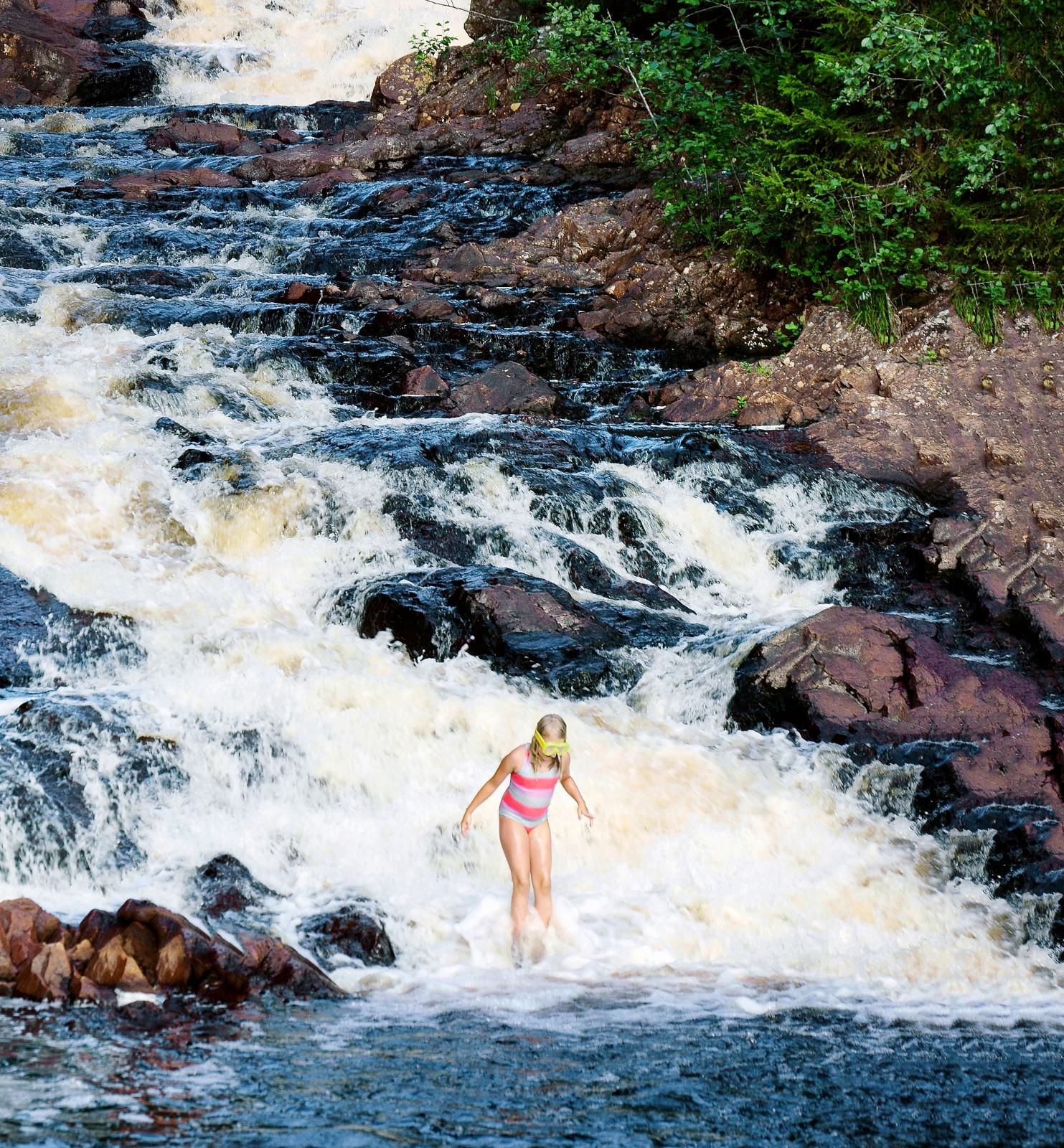 Under den 44 meter höga forsen skummar vattnet vitt. Ett naturens bubbelbad – en unik badplats där naturens möjligheter utnyttjas på fiffigt sätt.