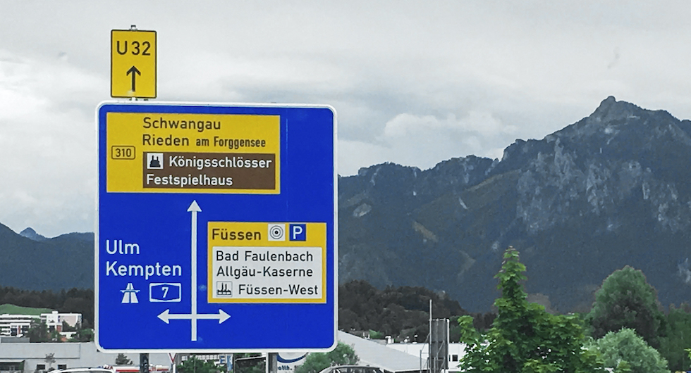 SÅ LÄSES SKYLTEN. Rakt fram ”Umleitung”, tillfällig omdragning av väg. Även Bundesstrasse (gul skyltning) mot ett slott och längre bort Rieden och längst bort ligger Schwangau. (Ju högre upp på skylten betyder desto längre avstånd dit).
Till höger ligger Füssen där det finns en p-plats med vacker utsikt. Sväng vänster för att komma till Autobahn A7 mot Kempten och Ulm (blå).
