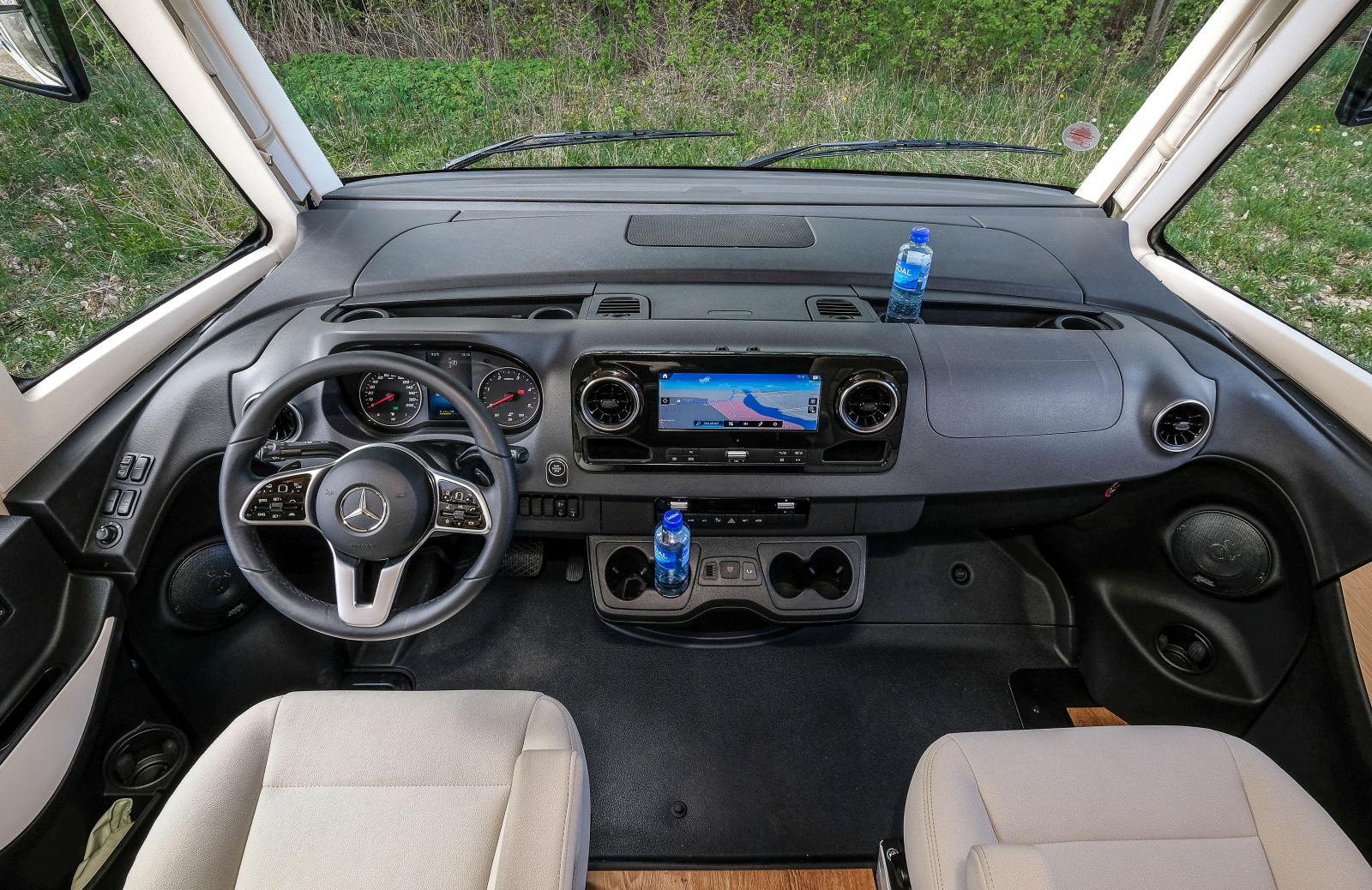Mängder av förvaringar och drickahållare i nya Mercedes-Benz Sprinter. Treekrad ratt fylld med knappar och bra skärm i mitten