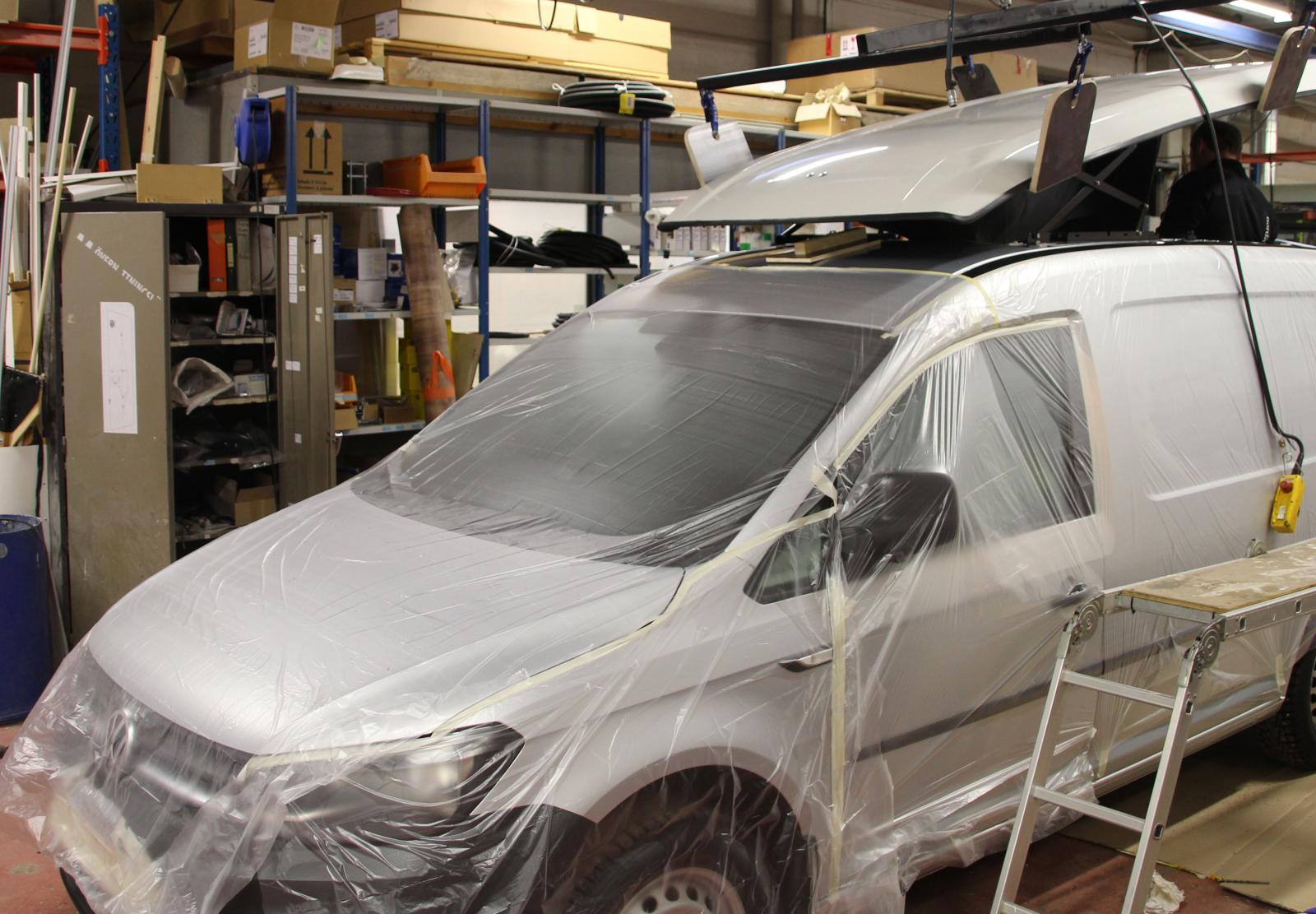 För att skydda lacken täcks bilen av plast.