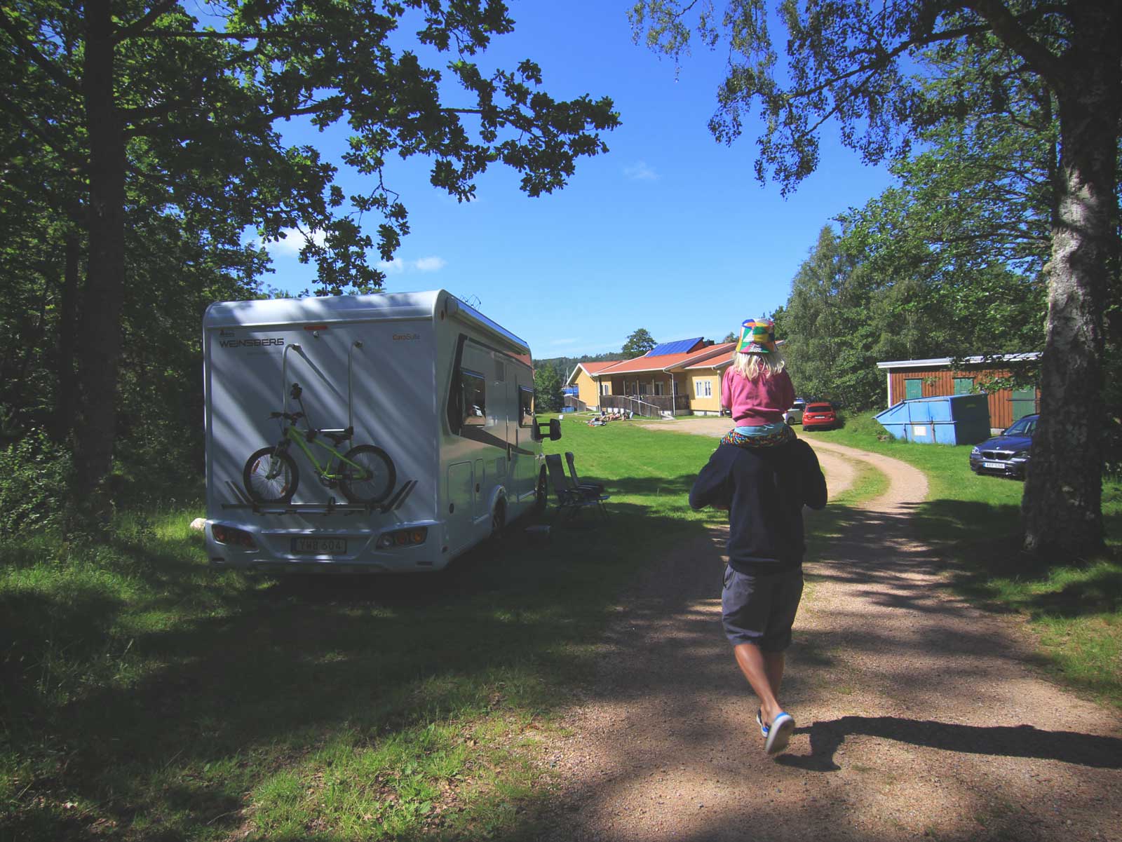 Pappa Niclas med Isafold på axlarna under en midsommarhelg med fricamping på Ängön, Orust.