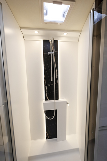 Duschen är stilren och fint belyst, i taket finns ventilation.