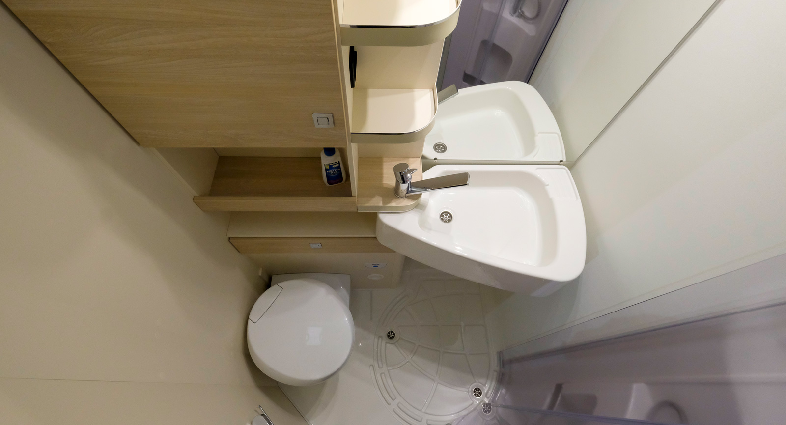 Allt i ett badrum men med smart handfat som kan svängas undan över toaletten innan det ska duschas.