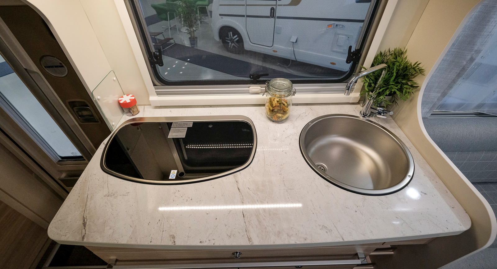Kompakt men bra utformat kök med smart lådsystem. Trelågig spis och djup diskho med hög vattenkran. Godkänd arbetsyta.