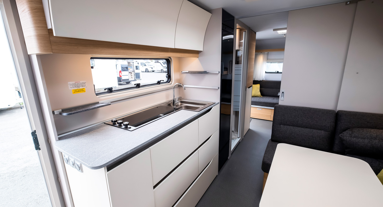Adria husvagnar har en modern och praktisk köksdesign. Tre spislågor på rad och diskho i samma enhet gör det lättstädat och runtom finns bra arbets- och avlastningsytor.