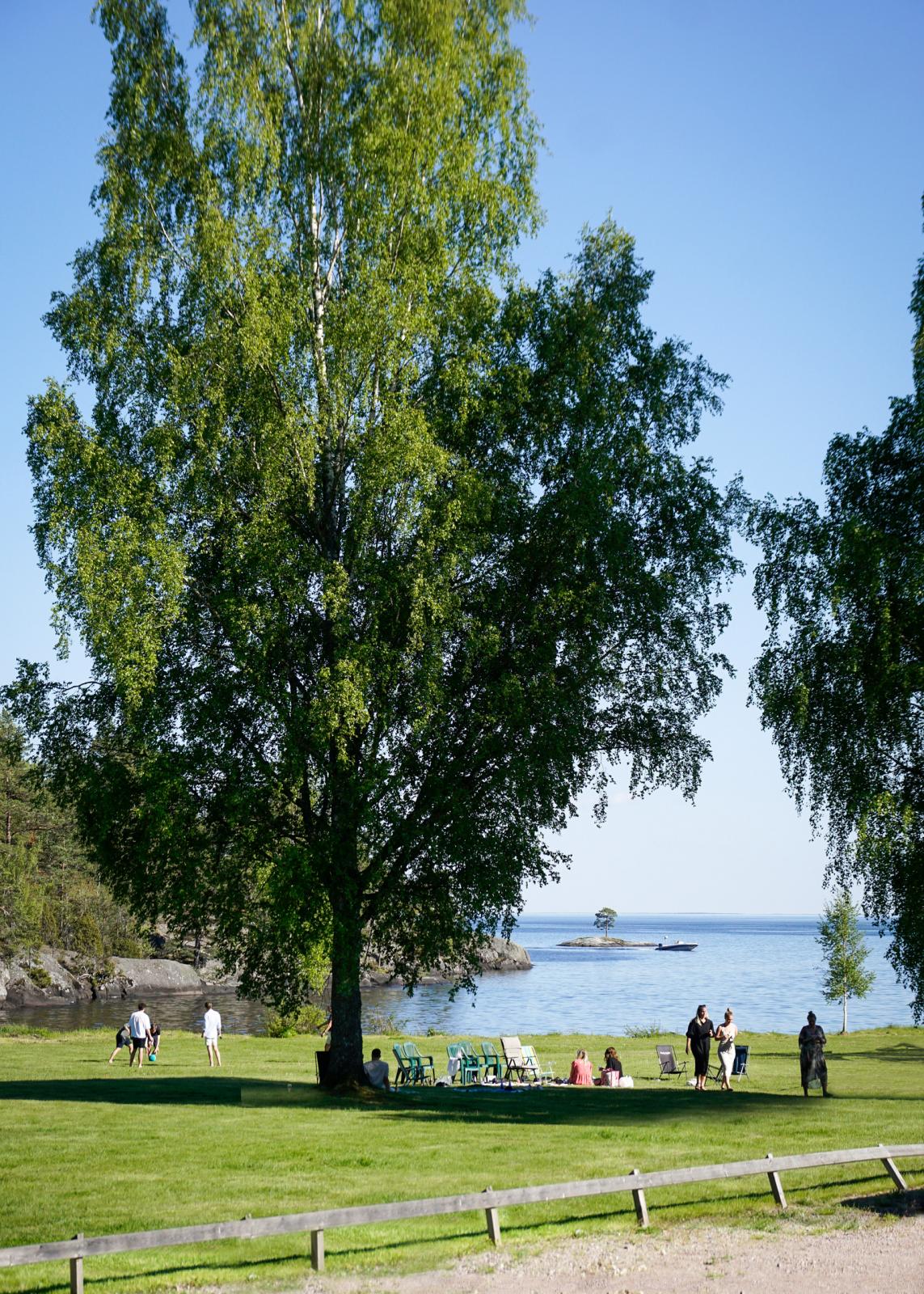 ... och plötsligt öppnar sig gräsytorna ner mot Vättern och ett härligt folkliv.