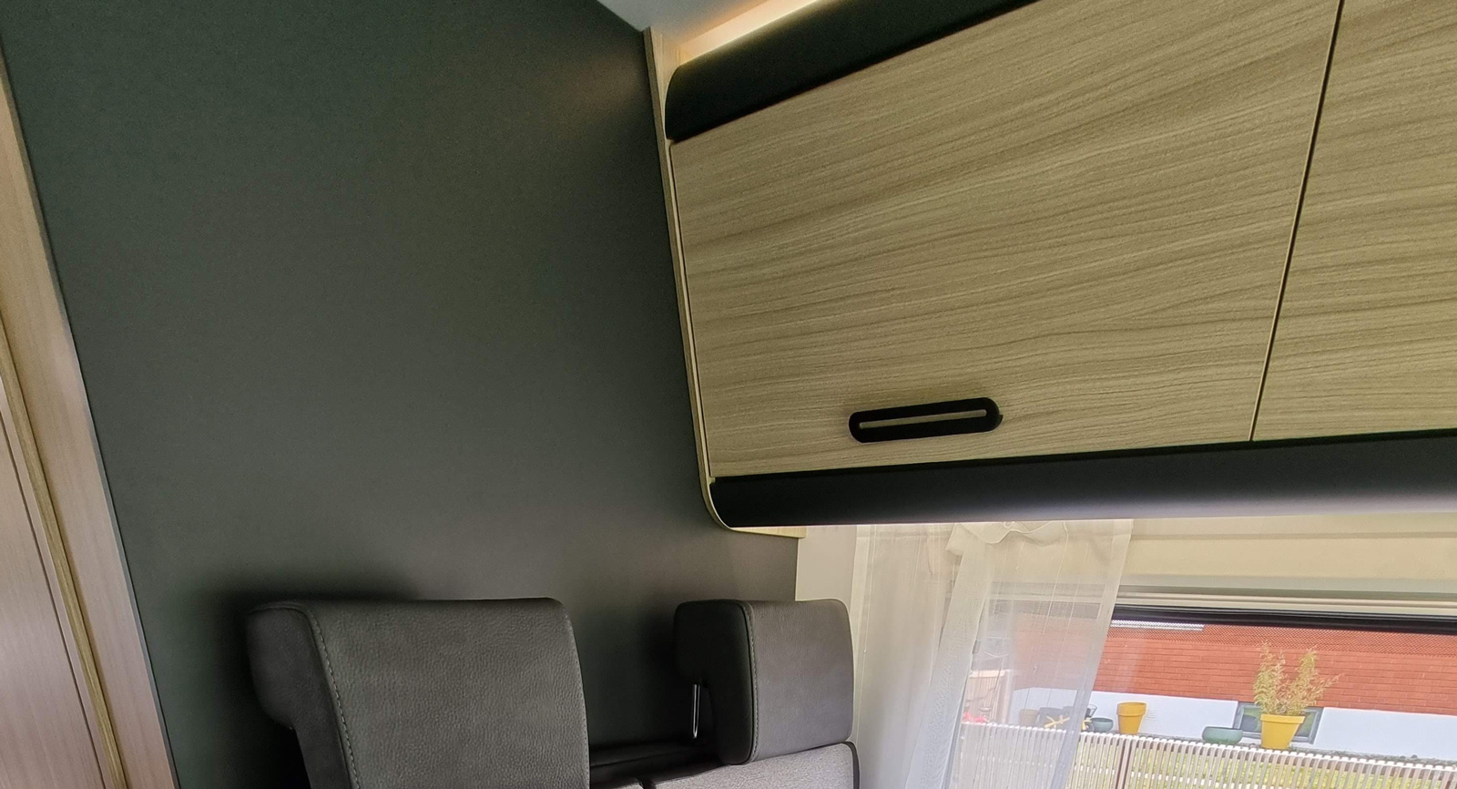 Överskåpen är raka och stilrena med ergonomiska handtag och på undersidan finns flyttbara USB-uttag och lampor på skena.