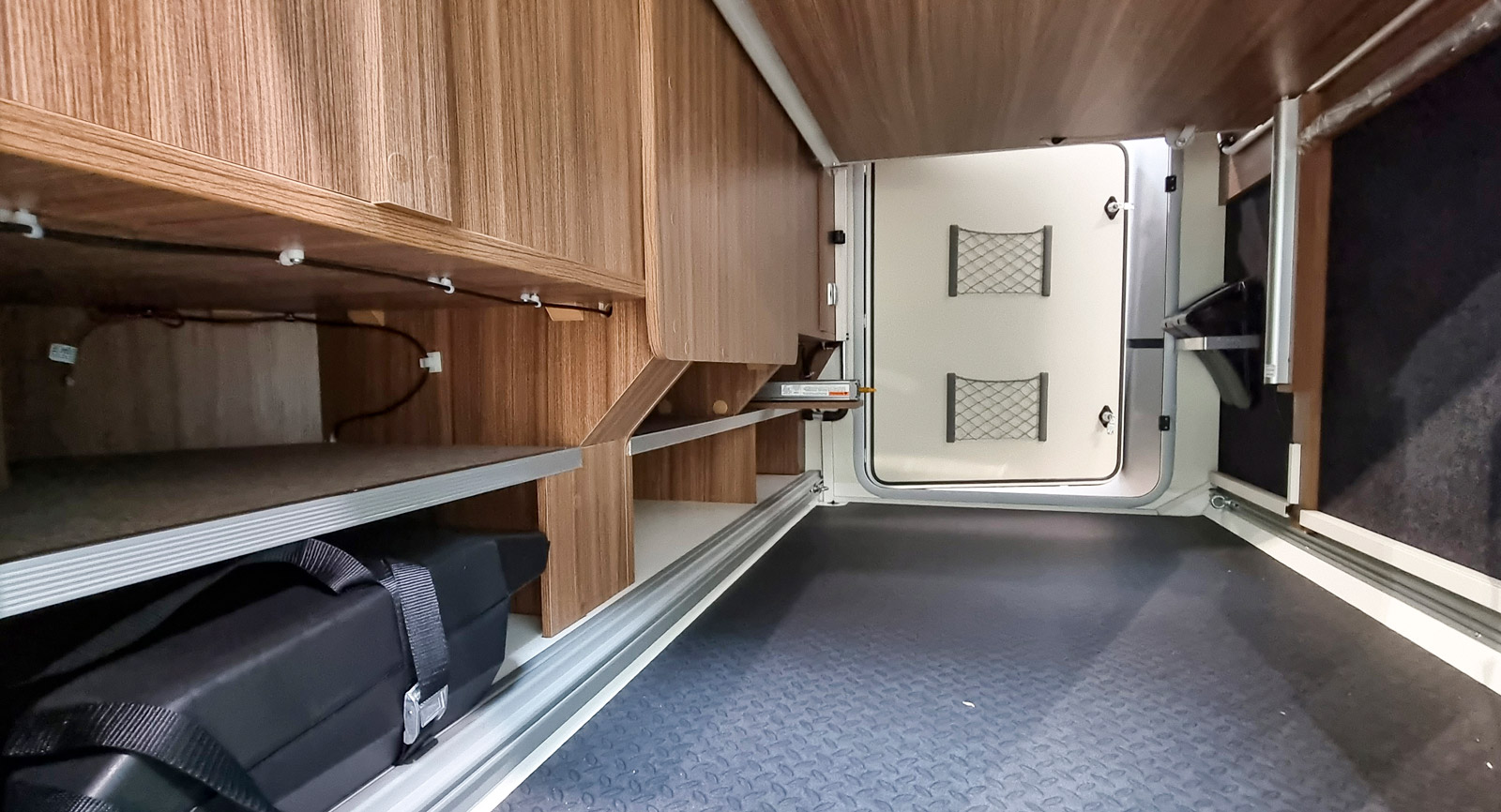 Rymligt garage för tvåhjulingar och luckor på båda sidor. Fack till dubbelgolvet för saker som tältstänger eller campingmöbler och hållare för småprylar på väggen.