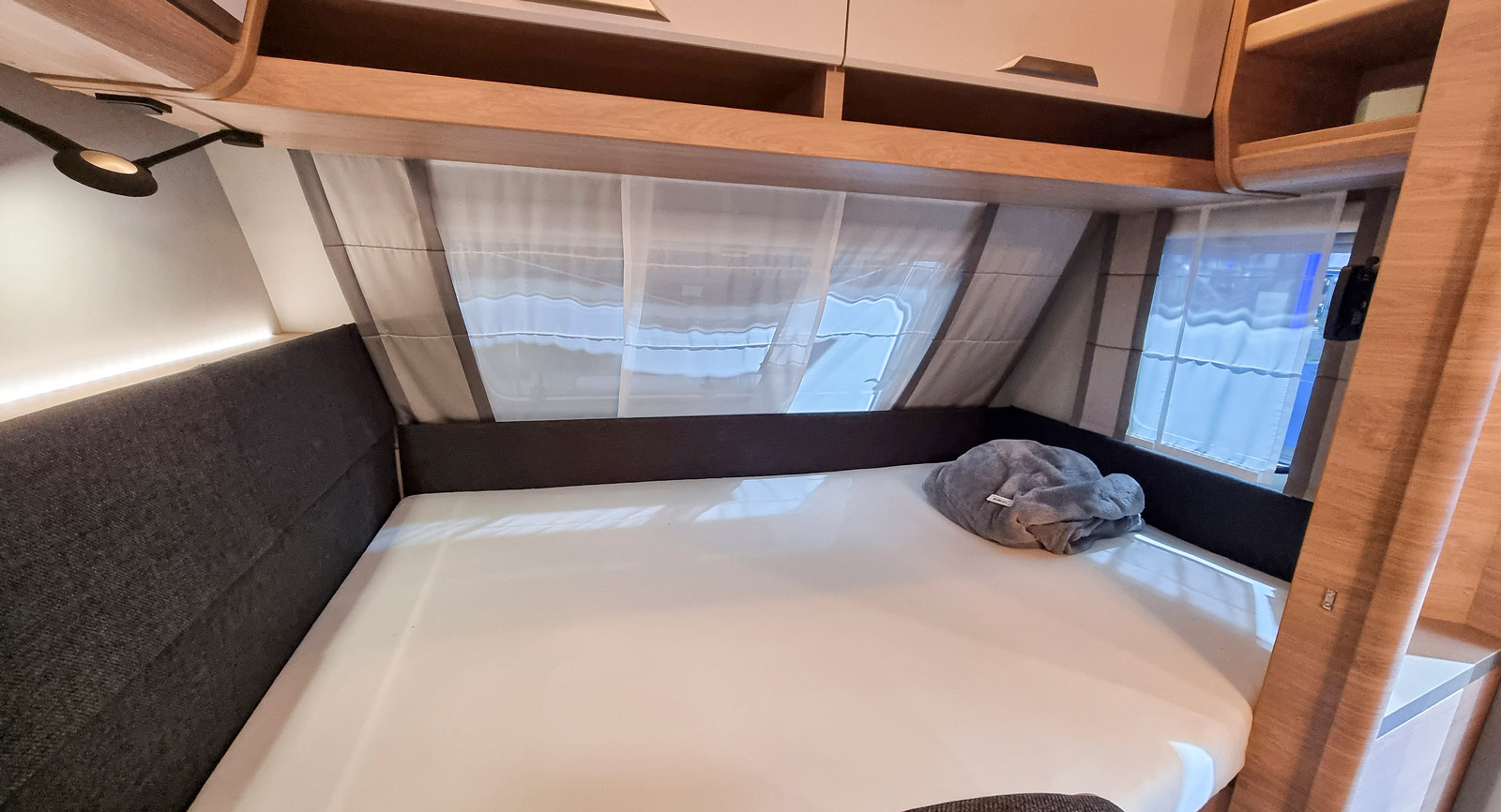 Sängen för de vuxna är placerad längst fram. Gott om överskåp, men också öppna hyllor. Plats för tv finns på ett förmonterat stativ.