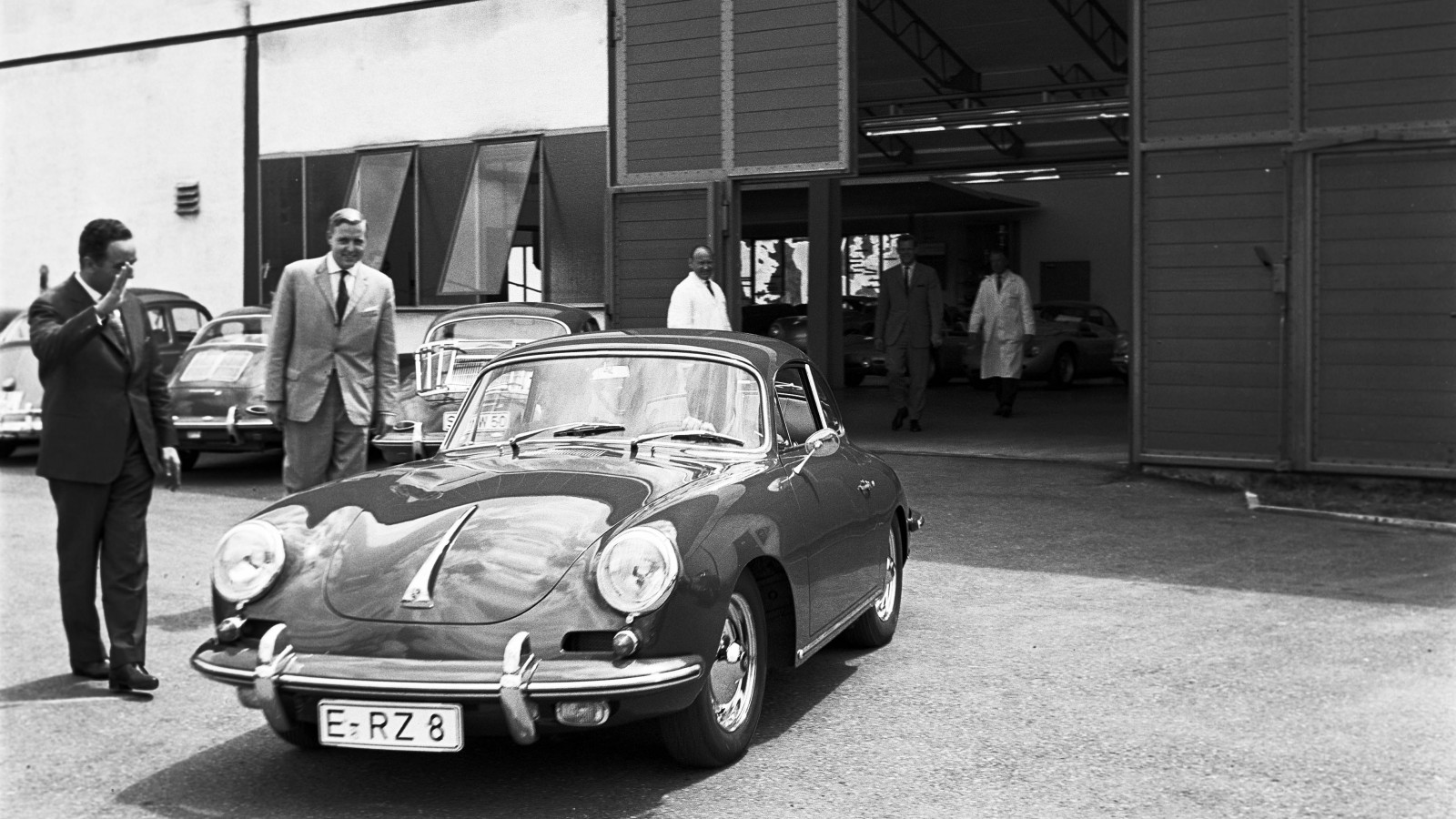 Porschemedarbetarna Harald Wagner och Alfried Krupp vinkar adjö åt den nyblivna 356 B-ägaren.