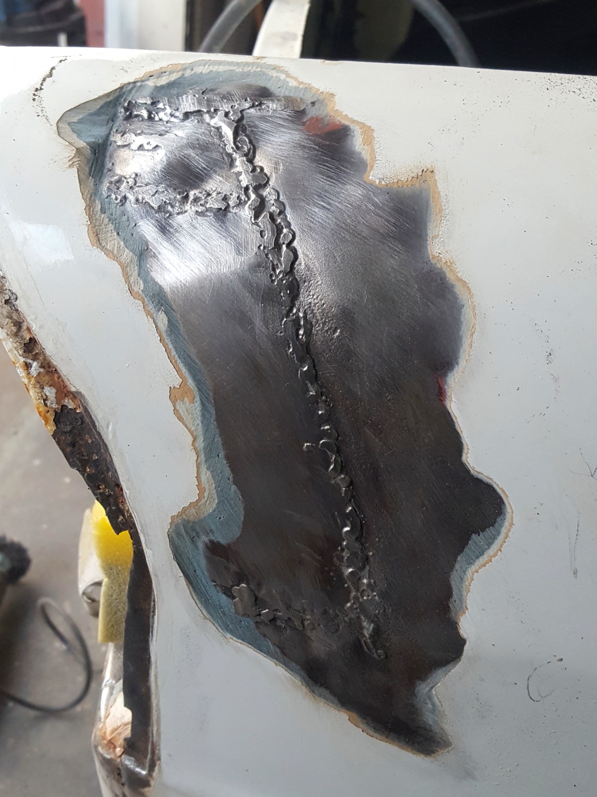 En liten spricka i lacken avslöjade en rejält ful lagning under 1-2 centimeter av glasfiberspackel.. Bilen har varit lite krockad både fram och bak. Här blev inte annat att göra än slipa bort allt och bygga upp med tenn istället.