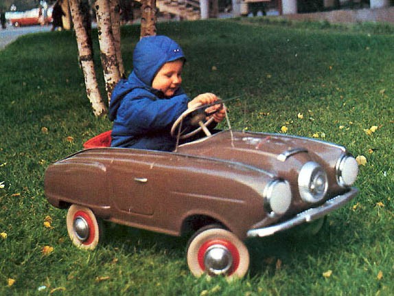 Glad ung sojvetmedborgare med sin nya fina trampbil från AZLK. Den här modellen är misstänkt lik en Studebaker