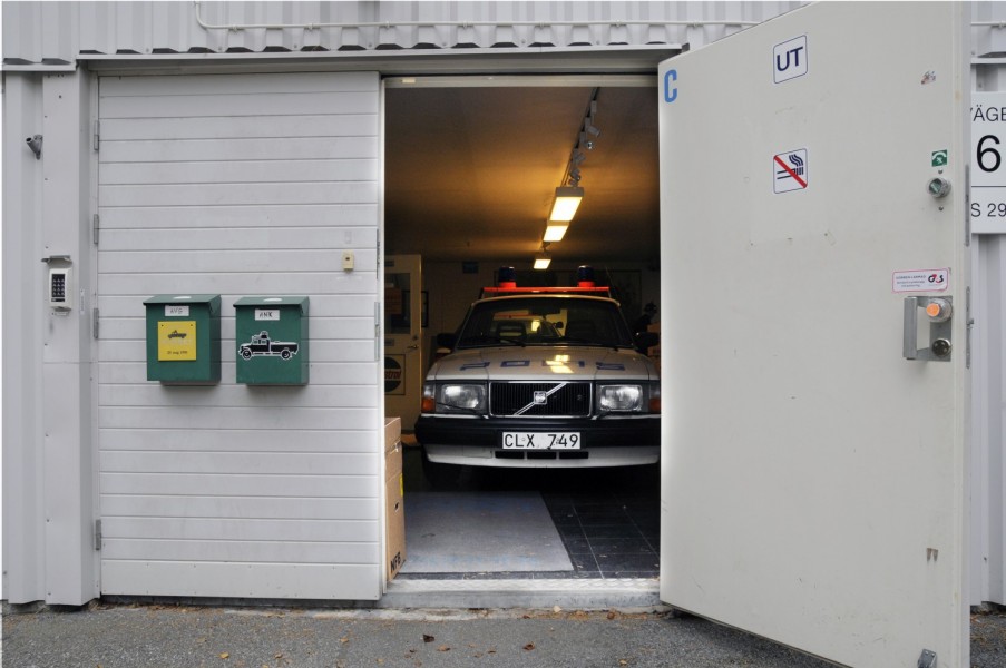 Tittut! Jag är den moderna öppna polisen med nyskapande typsnitt! Volvo 240 med så kallad hockeyklubbsdekor kikar ut ur dörren på det som var Polistekniska Museet.