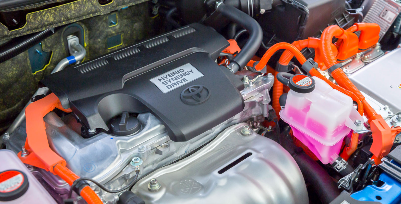 Toyotas färgglada motorrum inrymmer både bensin- och elmotor. Effekten är testets högsta och bilen har riktigt raska fartresurser när den pressas en smula – till priset av ett oskönt, råmande motorljud. På tomgång är motorkombinationen desto mer tystlåten.