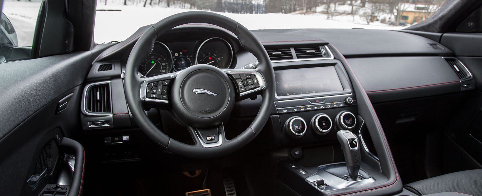Allt koncentrerat till förarens sida i en egen, lågbyggd stil med bättre finish än i F-PACE. Växelväljaren liknar BMW:s, den typiska ”Jaguarrundeln” är slopad i E-PACE. Inte riktigt lika vasst multimediasystem som i BMW.
