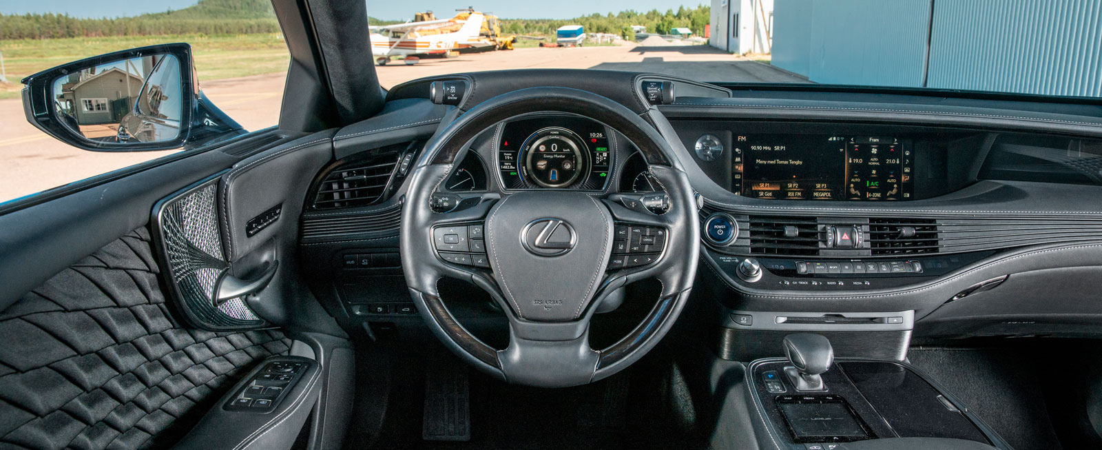 Det är ganska mörkt och dystert på Lexus förarplats. Knapparna i ratten är närmast osynliga i dagsljus och mediesystemets pekplatta kräver träning.