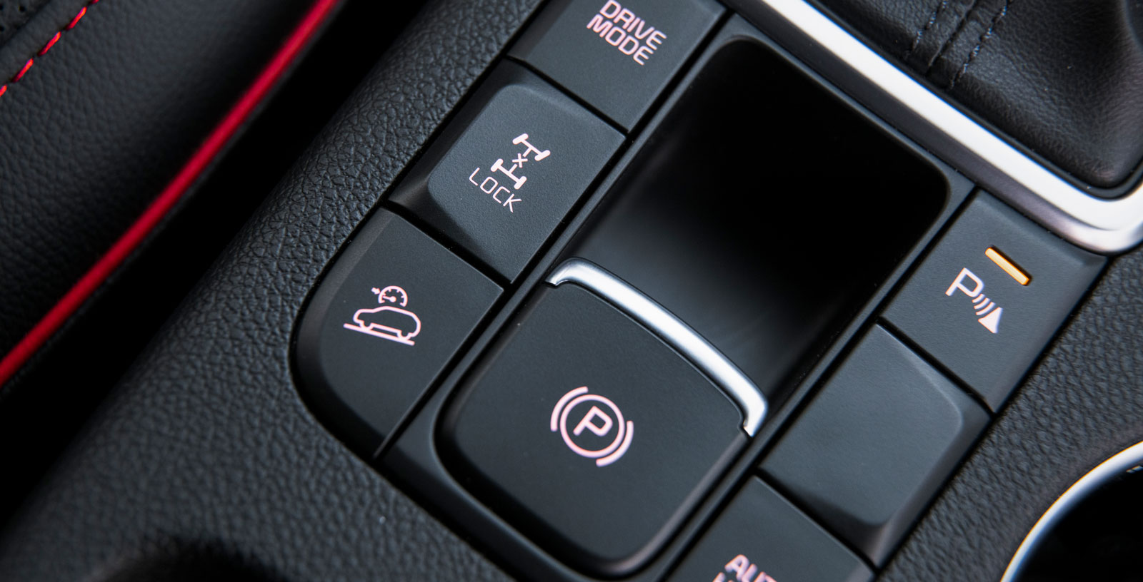 ”Lock” låser fyrhjulsdriften elektroniskt till 50/50-drivning. Knappen under används för att i utförslöpor hålla bilen i en konstant, låg hastighet.