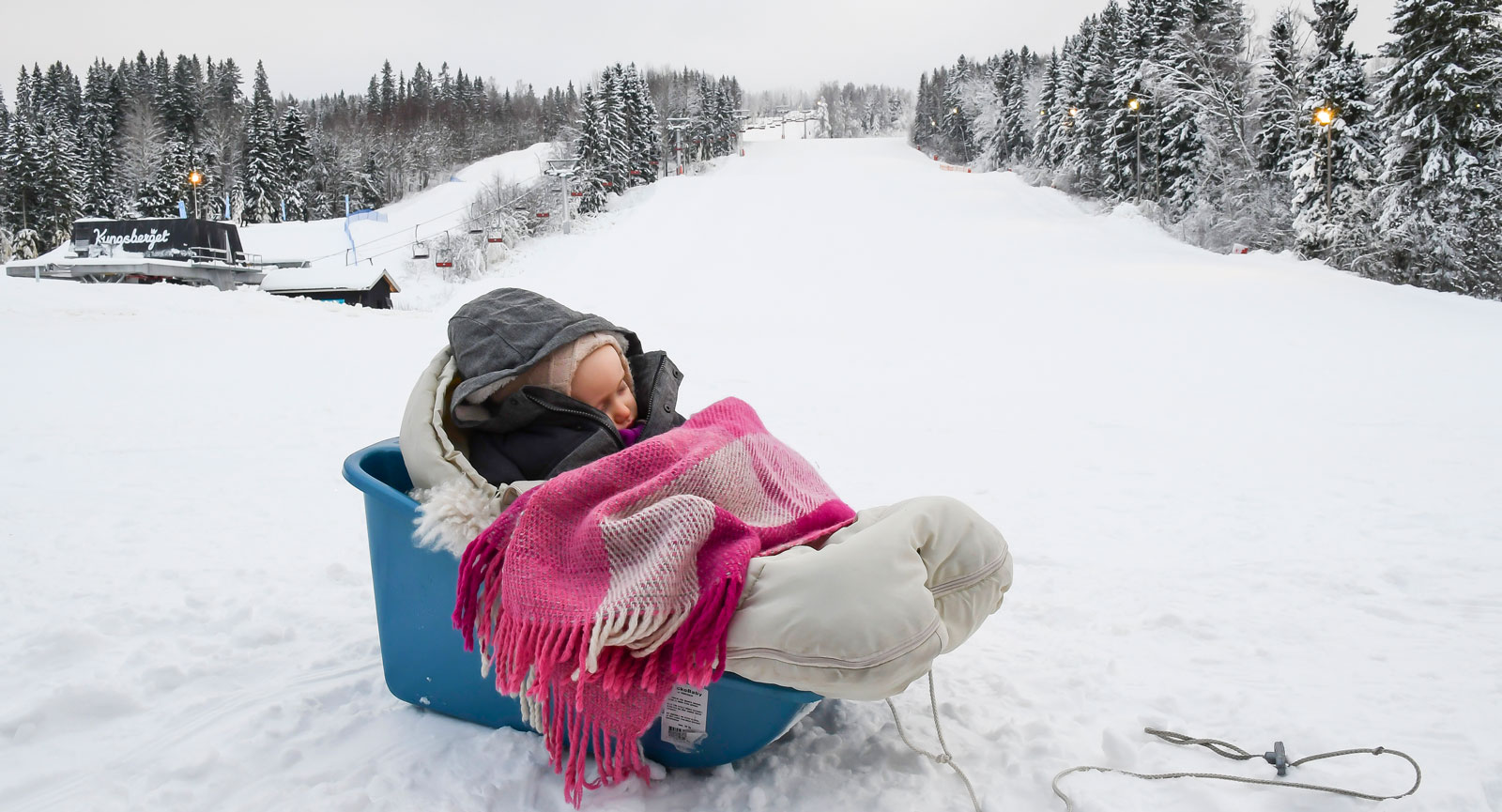 Lilla Lottie sover gott medan föräldrarna turas om att åka upp i backen.