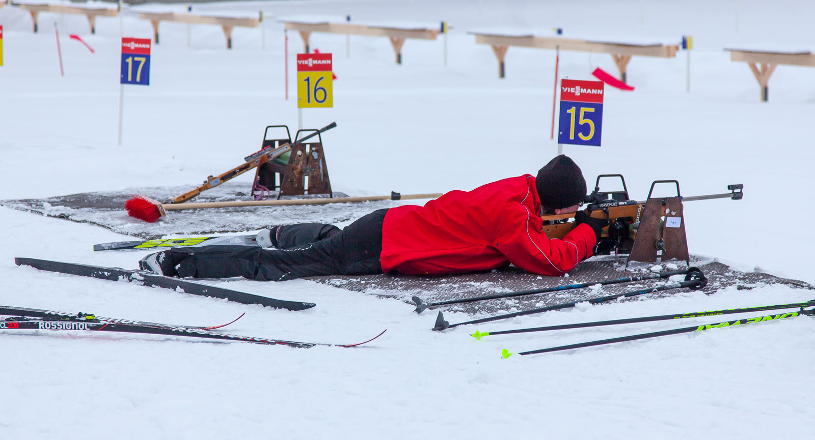 Obekväm ställning i skidskyttet, liggande med skidorna spretande åt olika håll. Och pricktavlorna 50 meter bort.