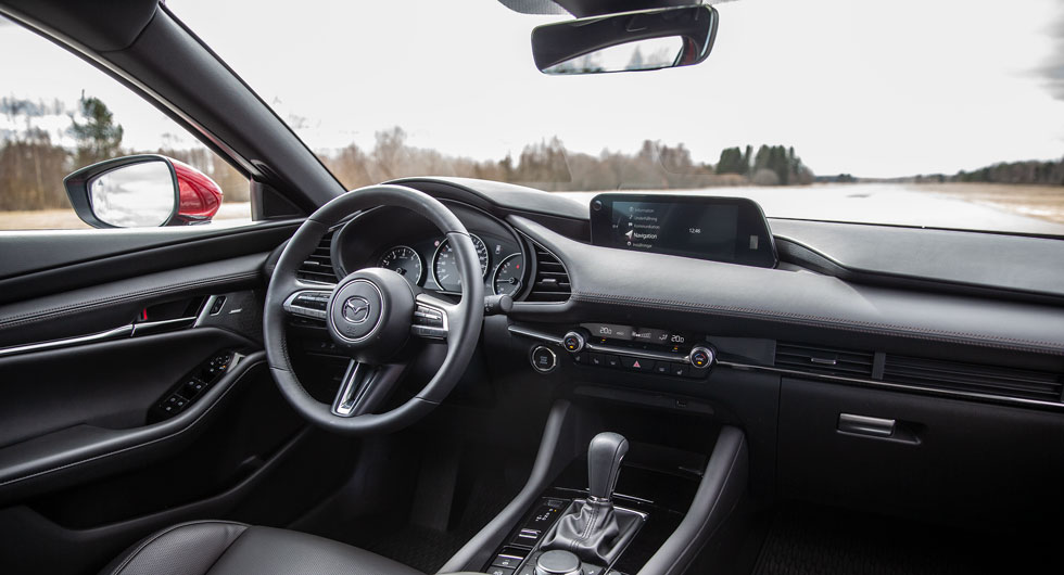 I Mazda 3 sitter man lågt och omsluten av höga karossidor. Reglagen som styr klimatanläggningen är inte så tydliga som man kan önska.