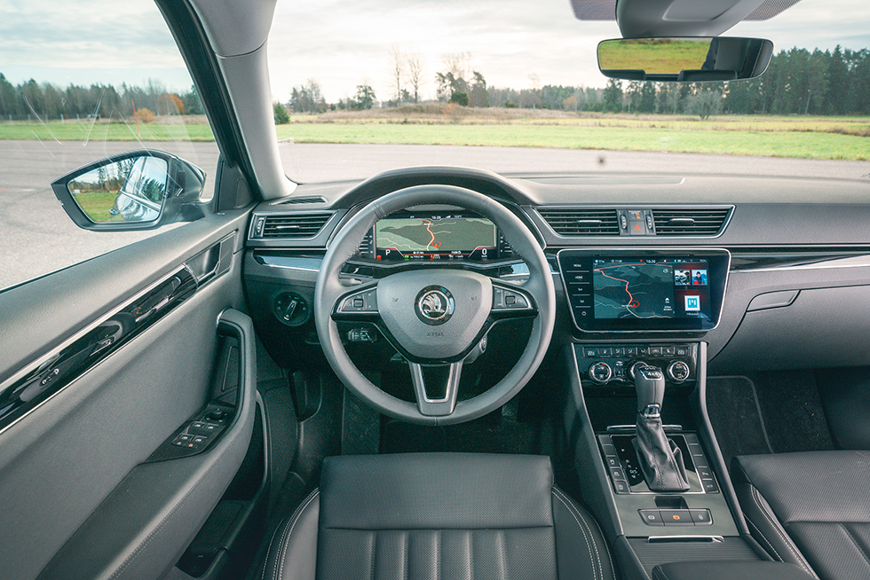 SKODA: Digitalt instrumentkluster och ny skärm är de ”stora” nyheterna i förarmiljön. Mugghållarna döljs under dragjalusien bakom växelväljaren.