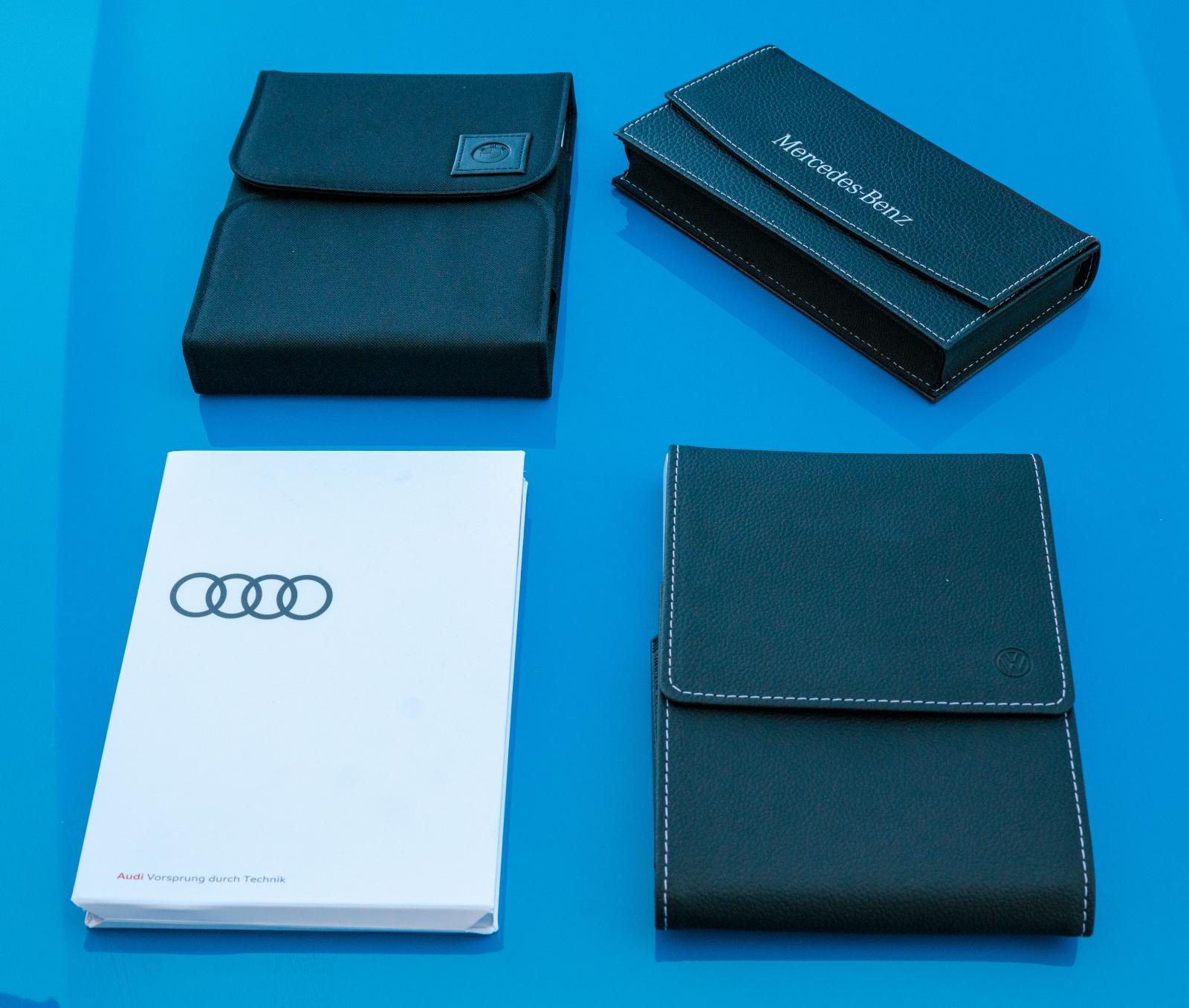 402 sidor BMW-manual (övre vänstra) levereras i textilfodral. Audis instruktionsbok huserar i ett mer miljövänligt pappersfodral. Mercedes och VW konstläderfodral har kontrastsömmar – påkostat.
