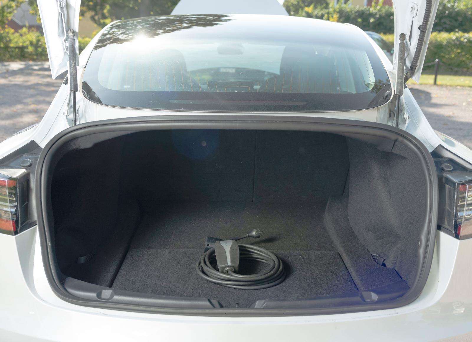 Man får sträcka sig rejält för att nå längst in i Teslas bagageutrymme. Eller också får man fälla de bakre ryggstöden från kupén. Lastöglor saknas men under golvet finns fack för sladdar och avtagbar dragkrok.