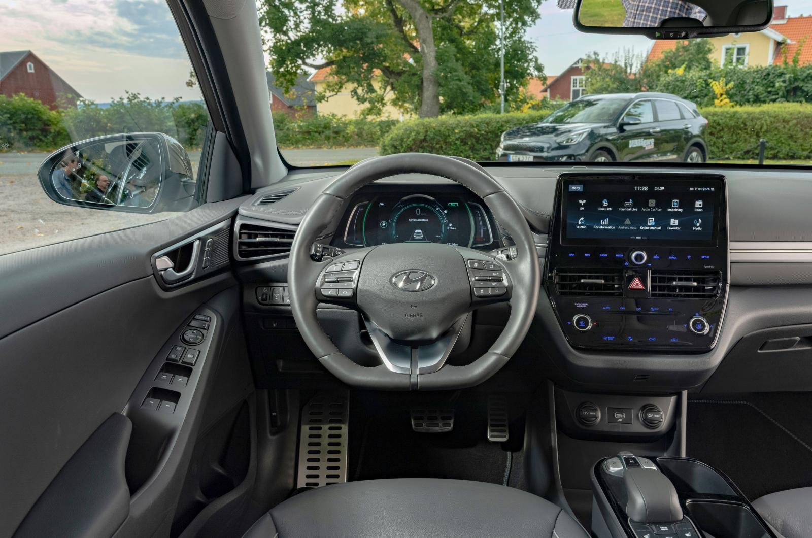 Hyundai: Nedtonat, nästan som ett svartvitt foto, utmärkt finish och logisk skötsel utmärker Ioniqs förarplats. Växelväljare med knappar mellan stolarna.