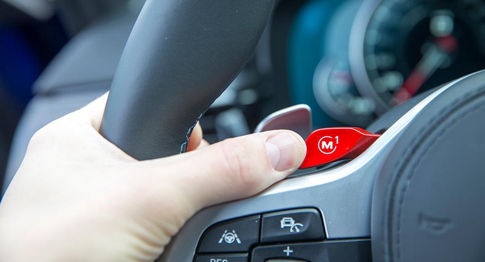 Röda rattknappar sticker ut i den annars sobra inredningen. Tryck med tummen för att skifta inställning för styrning, växellåda, fjädring, drivning, etcetera.