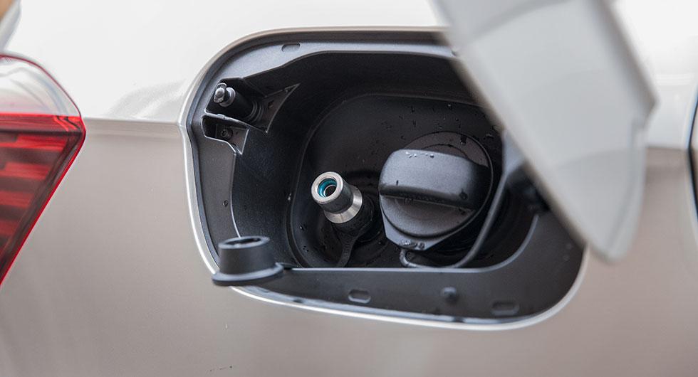 Gas fylls i nippeln till vänster och bensin till höger.